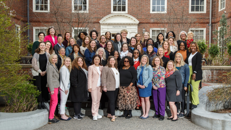 A group of diverse women stand outside the Harvard Faculty Club