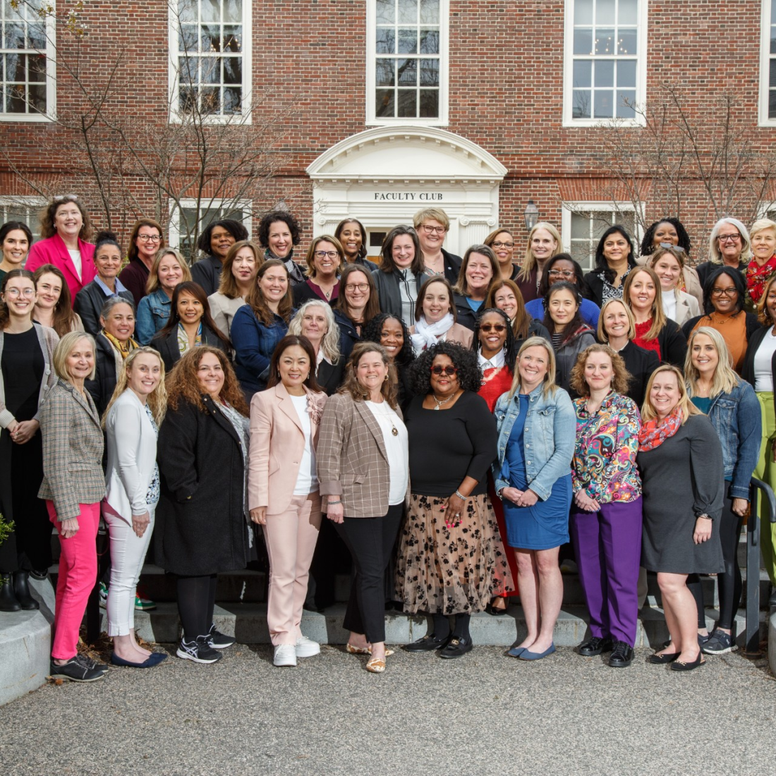 A group of diverse women stand outside the Harvard Faculty Club